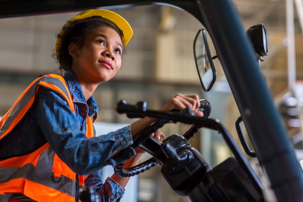 women worker at forklift driver happy working in industry factory logistic ship.